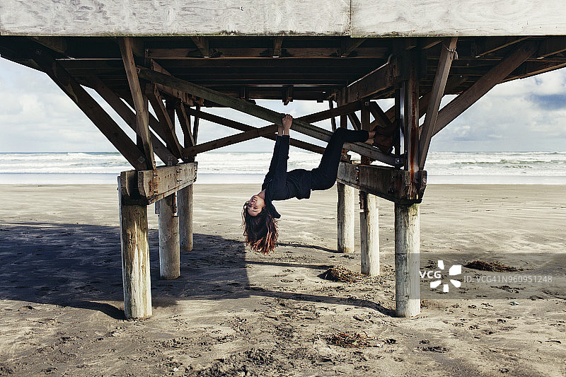 贝瑟尔斯海滩，一个女人吊在木结构上图片素材