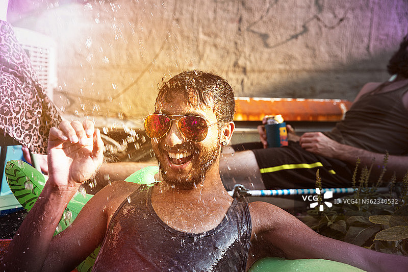 快乐的男人享受在涉水池在游园会图片素材