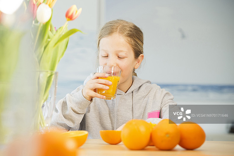 女孩喝橙汁的肖像图片素材