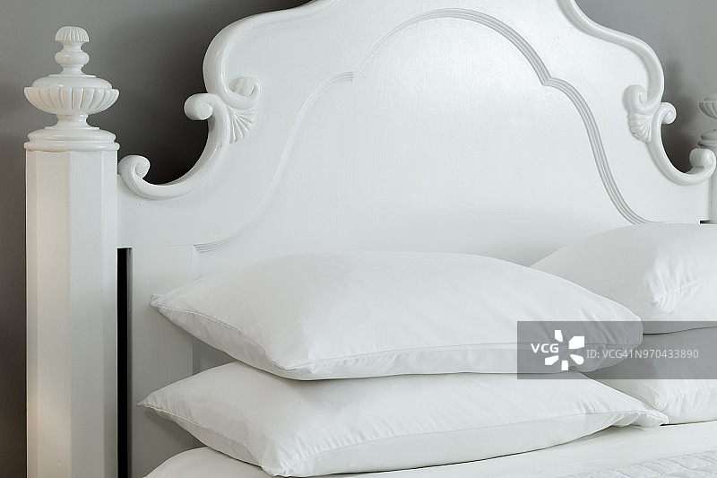 近距离观察明亮通风的现代卧室，灰色油漆和白色油漆的床，堆叠的枕头图片素材