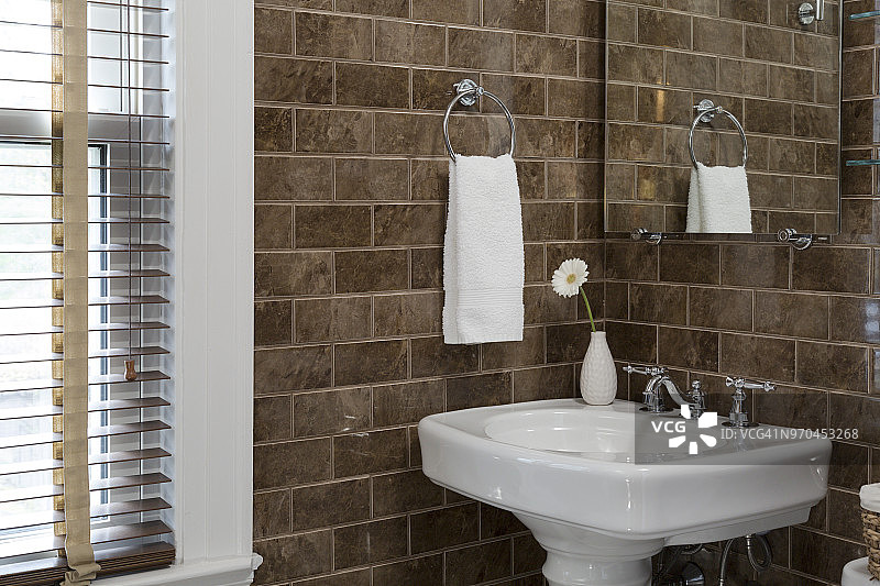 棕色地铁风格瓷砖在小型现代浴室与梳妆台水槽和白色口音图片素材