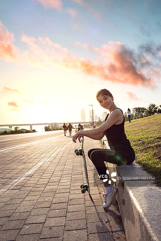 年轻的少女与滑板有乐趣在城市图片素材