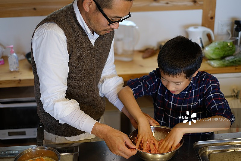 男孩和父亲一起在厨房做饭图片素材