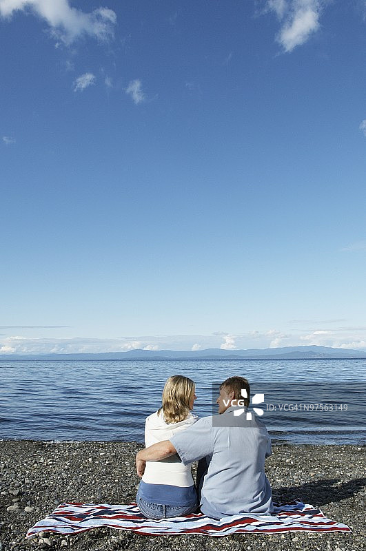 一对夫妇坐在海滩上图片素材