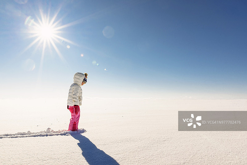 女孩站在白雪覆盖的乡村景色中图片素材