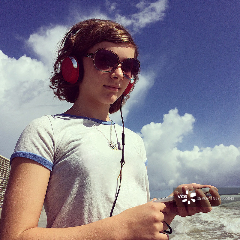 在海滩上戴耳机的女孩图片素材