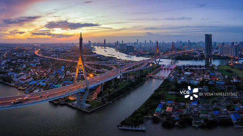 鸟瞰图普密蓬悬索桥横跨湄南河在曼谷市与汽车在桥上在日落的天空和云在曼谷泰国。图片素材