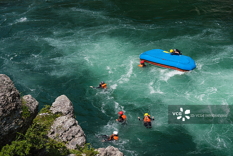 木筏翻倒后，一小群男人和女人漂浮在河中图片素材