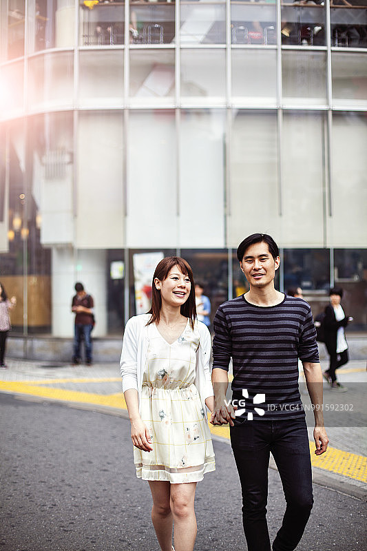 快乐的年轻夫妇对城市景观背景，东京。图片素材