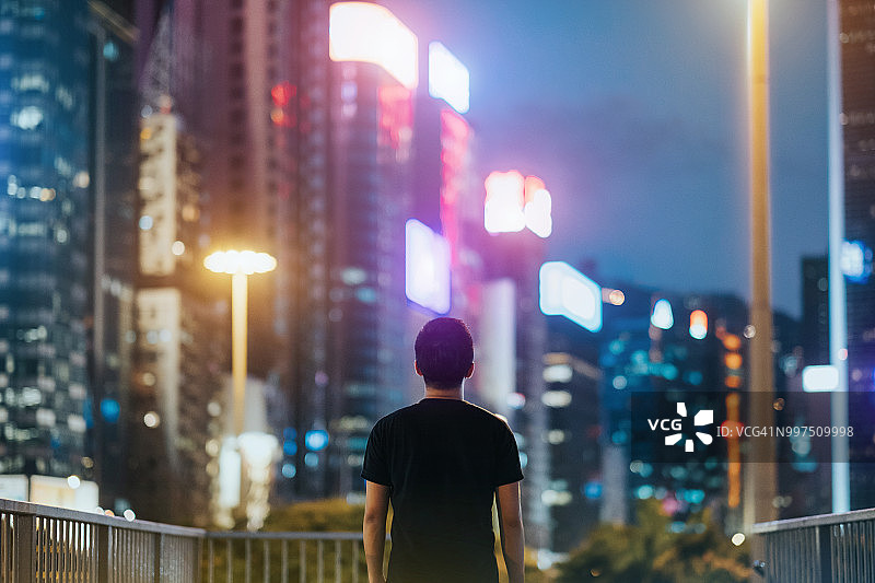 人看城市的后景，繁华而充满活力的城市，高楼大厦上五颜六色的霓虹商业灯光图片素材