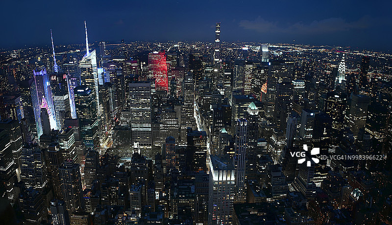 黄昏时分从帝国大厦楼顶俯瞰的壮观全景:时代广场、通用电气大厦、洛克菲勒中心、公园大道432号、大都会大厦、克莱斯勒大厦。美国纽约市图片素材