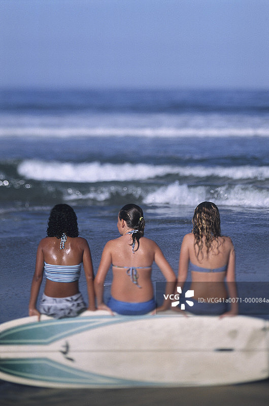 女孩们坐在冲浪板上图片素材