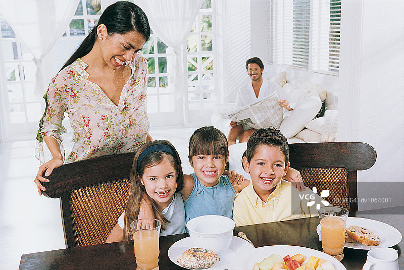 一个家庭的肖像，孩子们坐在桌子旁图片素材