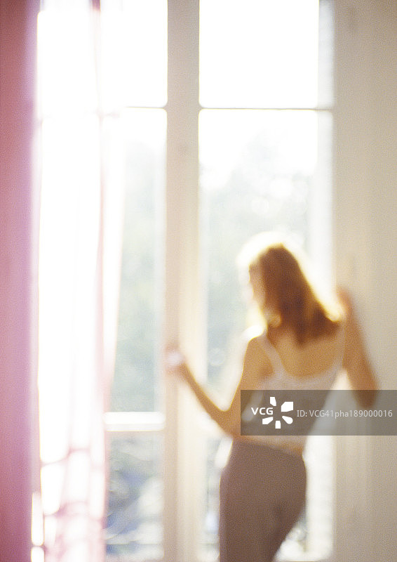 女人望着窗外，后视镜，四分之三的长度，模糊不清。图片素材