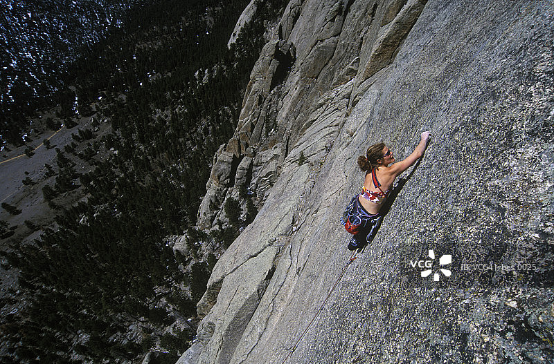 生活方式的照片，一个年轻的成年女性攀岩者，因为她爬上悬崖面图片素材