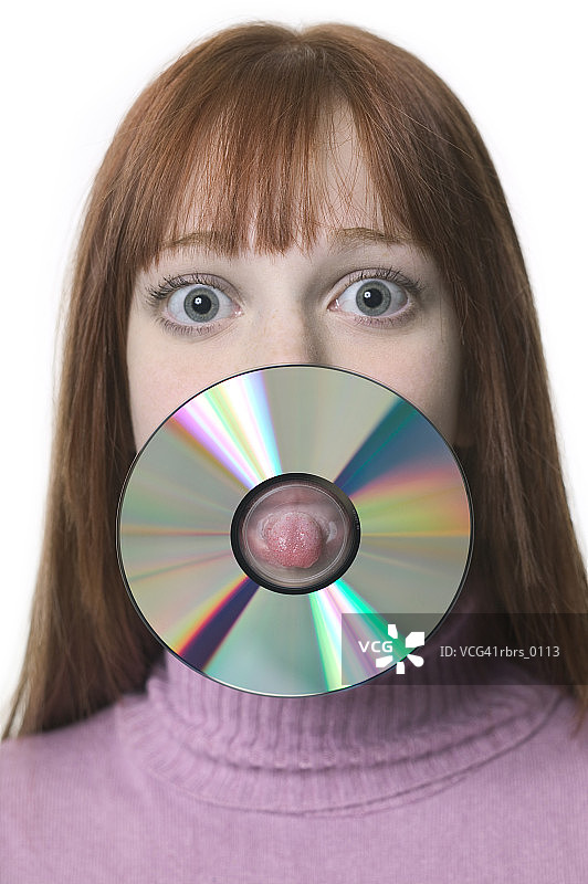 近距离拍摄的一个十几岁的女性，因为她伸出她的舌头通过一张CD图片素材