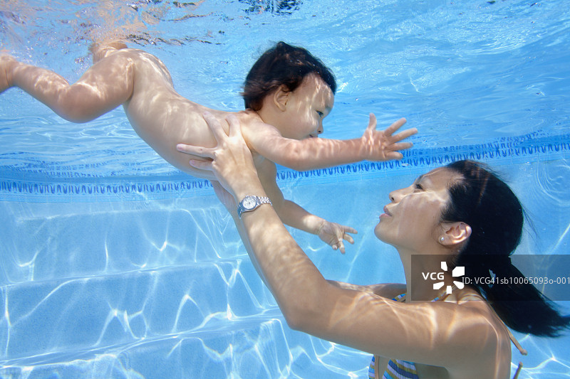 母亲和男婴(13个月)在水下图片素材