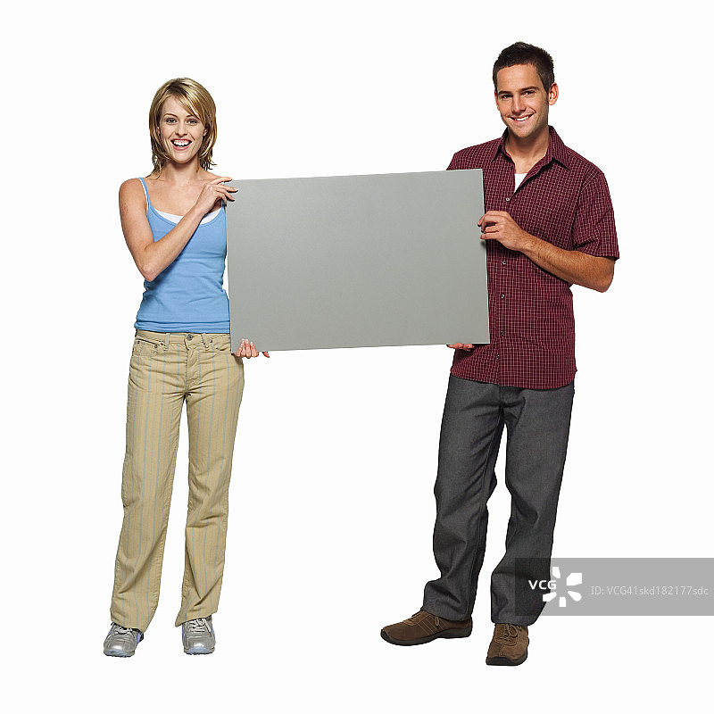 这是一对年轻夫妇手中拿着空白卡片的肖像图片素材