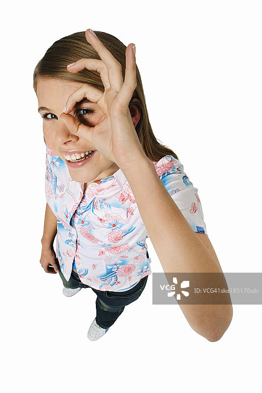 一个女人把手指举到眼睛上的高视角图片素材
