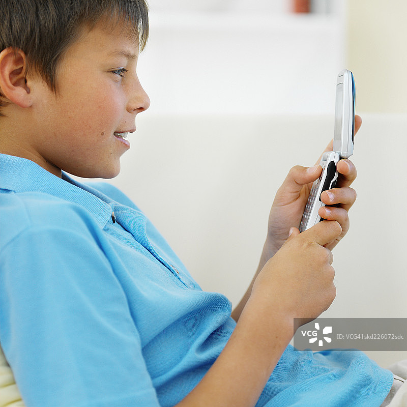 男孩(11-12)拿着手机的侧视图图片素材
