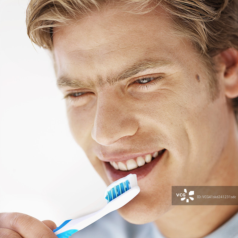 年轻男子用牙刷刷牙的特写图片素材
