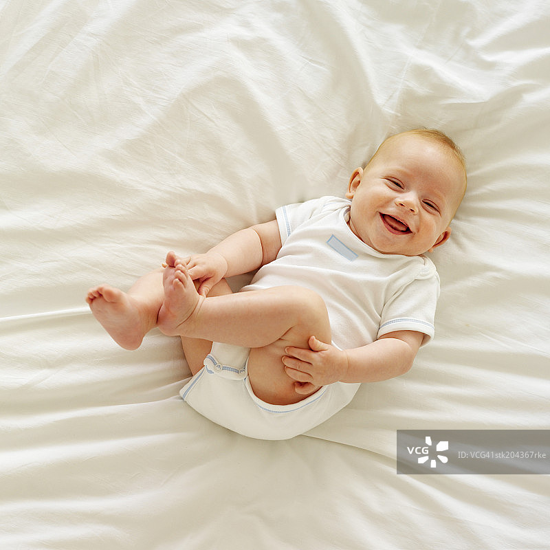 婴儿(12-18个月)躺在床上的高架视图图片素材