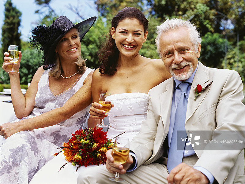 一个新娘和一个成熟的男人和成熟的女人喝酒的肖像图片素材