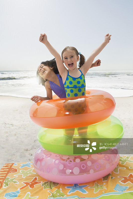 热情的女孩在沙滩上玩充气环的肖像图片素材