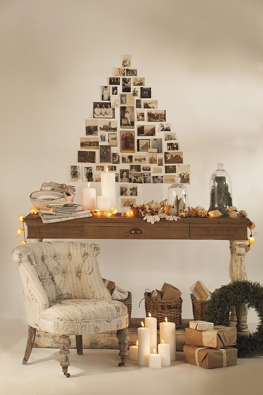 节日装饰的木桌，地板上的圣诞礼物和墙上怀旧照片制成的圣诞树形状摄影图片下载