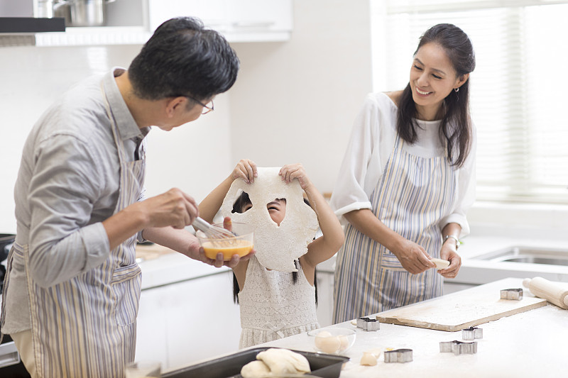 快乐小女孩和爷爷奶奶在厨房制作饼干图片下载