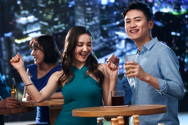 快乐的青年人在酒吧喝酒图片素材