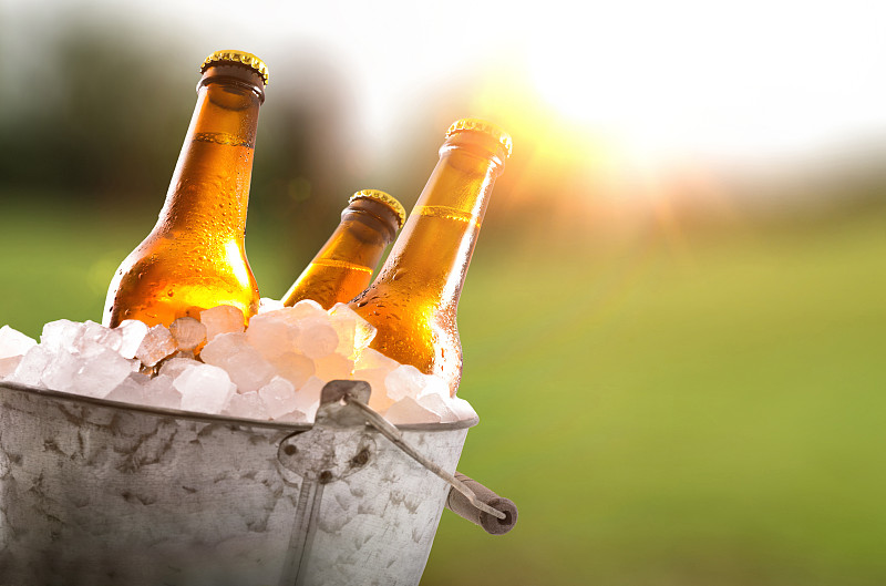 三瓶啤酒放在装满冰块的桶里图片素材