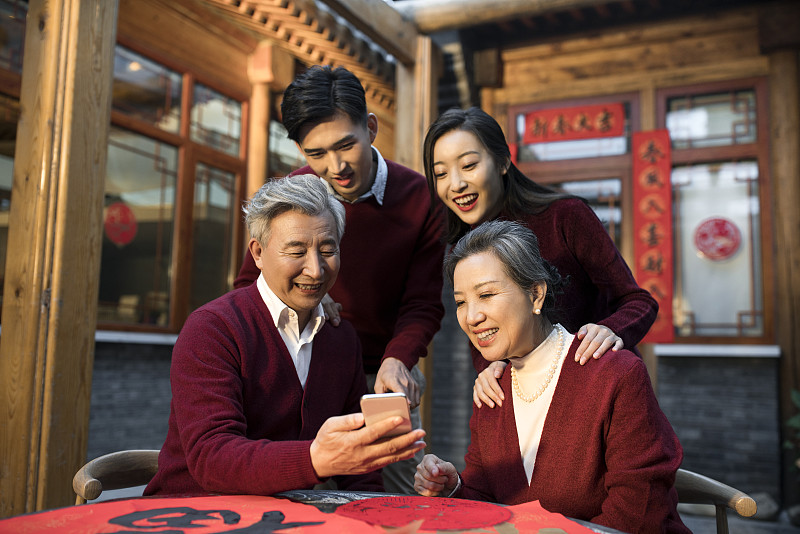 快乐的一家人新年使用智能手机图片下载