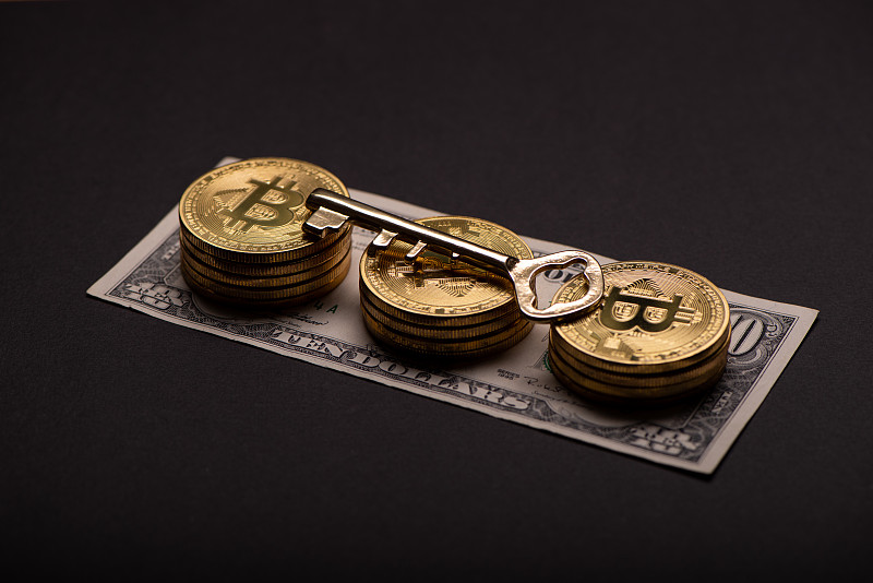 黑色背景上的金融比特币和复古钥匙图片素材