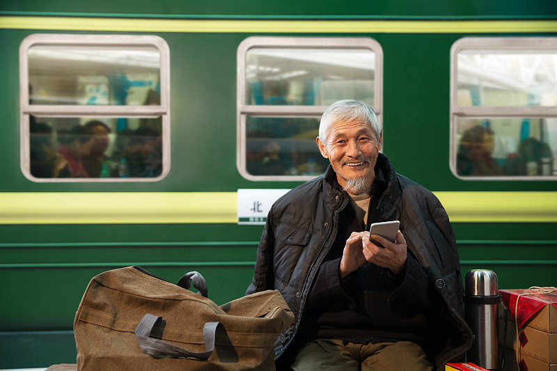 在火车站台上用手机的老人图片下载