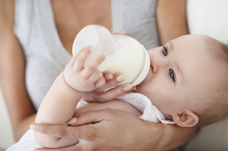 小女孩喝着奶瓶里的牛奶图片素材