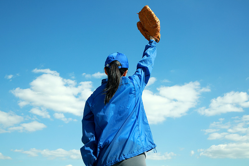 戴着棒球手套举起手臂的女人图片下载