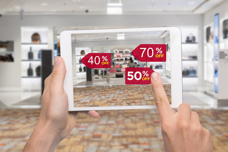 增强现实营销概念。手持数字平板智能手机使用AR应用程序查看特价零售时装店商场图片下载