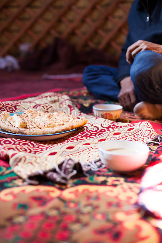 中国新疆，成年吉尔吉斯男子在一个帐篷里喝茶图片下载
