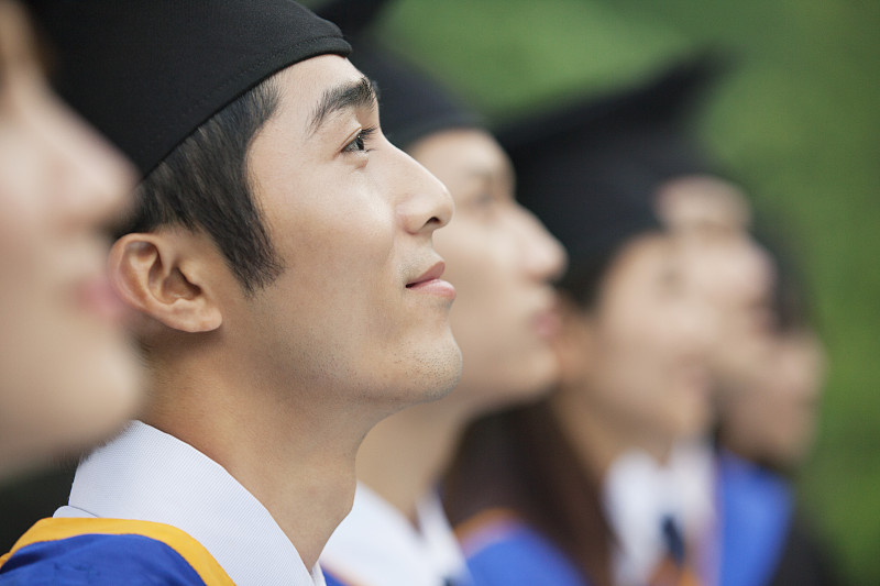 中国毕业生戴着帽子，穿着学士服图片下载