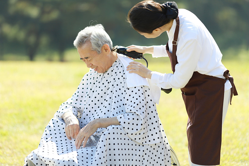 发型师用剪子为老年人理发图片素材