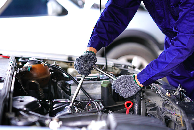 汽车修理工使用修理工具在车库检查汽车图片素材