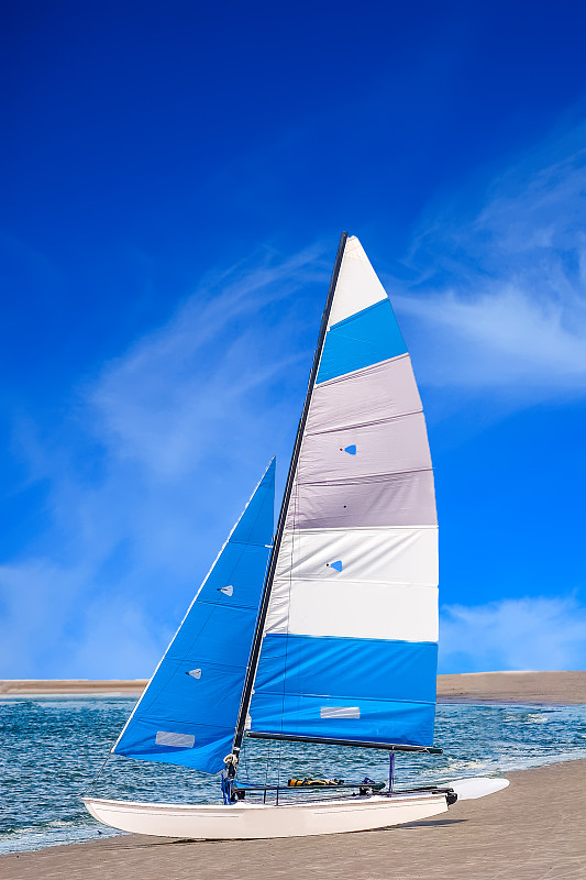 蓝天映衬下海滩上的帆船图片素材