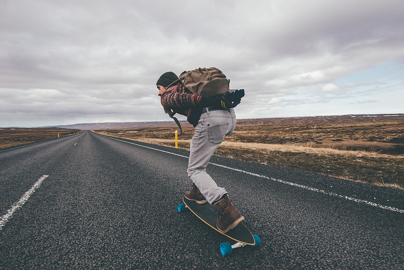 男子在高速公路上玩滑板图片下载