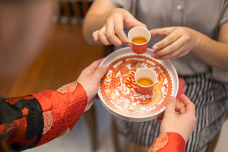 新婚夫妇在中国传统茶道上给老人斟茶图片素材