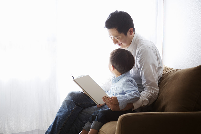 父亲和儿子一起看书图片素材