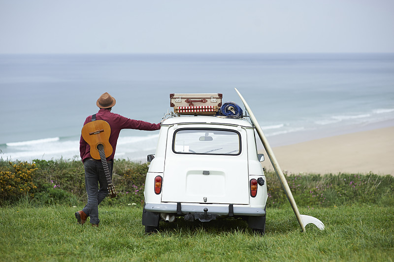 带着吉他和冲浪板上路旅行的潮人。图片下载