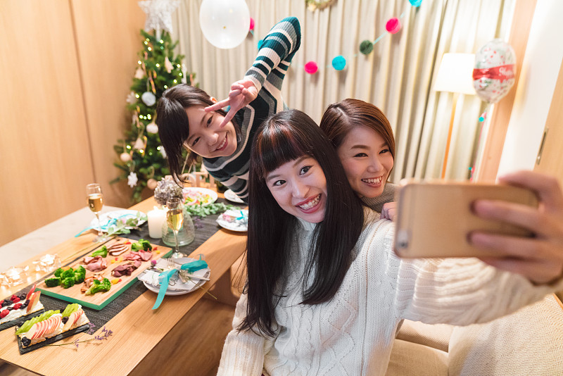 三个年轻的女性朋友庆祝圣诞节和自拍图片下载