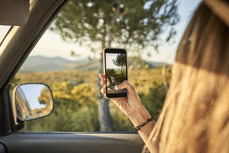 一名女子从车窗用手机拍照图片素材