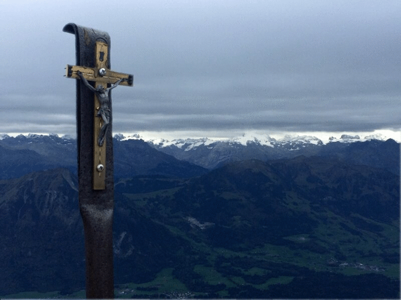 在瑞士阿尔卑斯山的十字架与快速移动的云图片下载